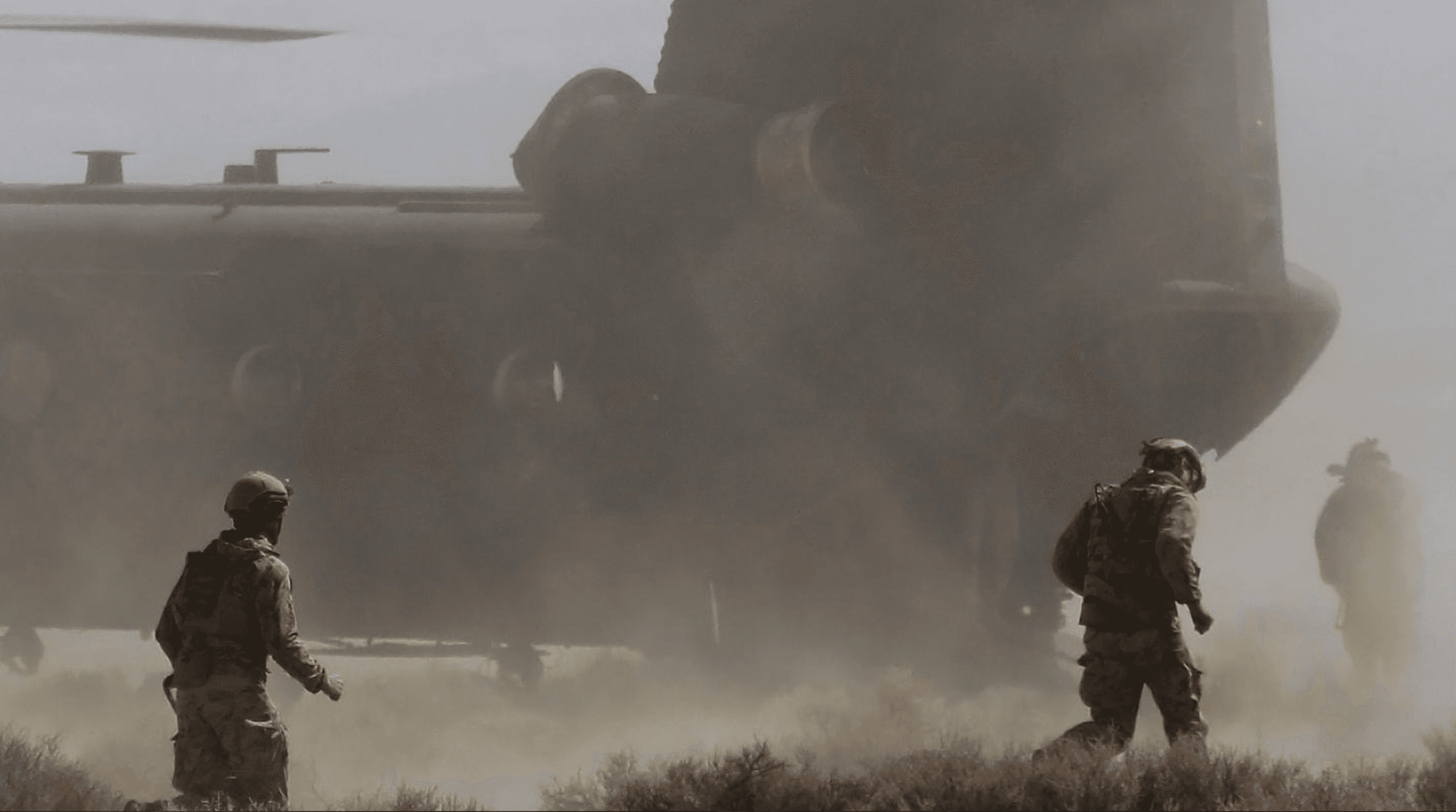 Operators moving through rotor wash near a transport helicopter